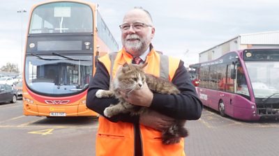 Stephen Howe carrying Dave the depot cat