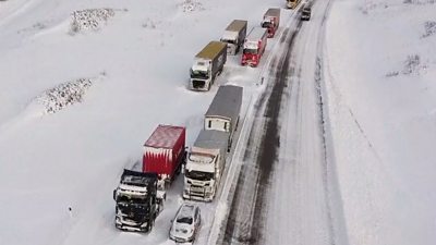 Long queue of lorries stuck in snow on motorway