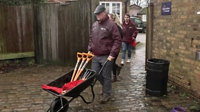 A Royal Park volunteer pushes a wheelbarrow