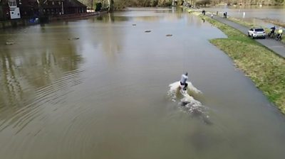Man wakeboarding through Berkshire flood water