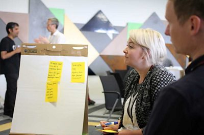 Woman looking at post-it notes on a whiteboard