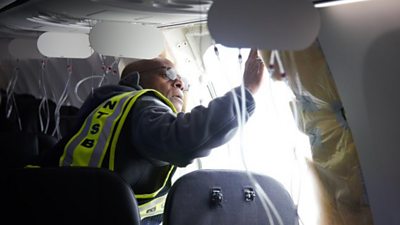Inspector examines hole in fuselage