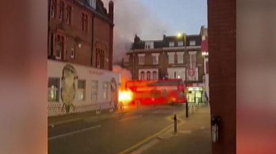 Red double-decker bus on fire