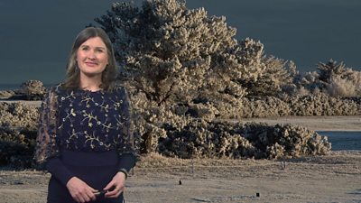 Helen Willetts stands in front of a wintry scene in Scotland