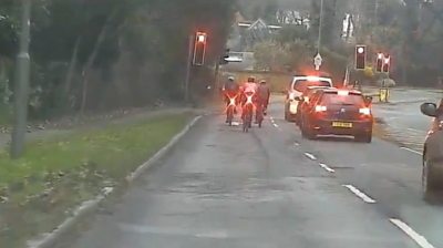 Cyclists about to go through red llight in Esher