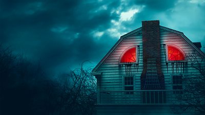 A creepy farmhouse at night with red windows. Copyright MGM