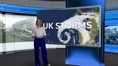 Sarah Keith-Lucas stands in front of a monitor with the words UK Storms on it
