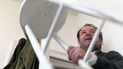 A man seen holding a stool in an Edinburgh flat