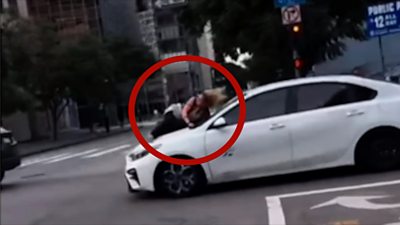 Woman clinging to the hood of a car in Los Angeles