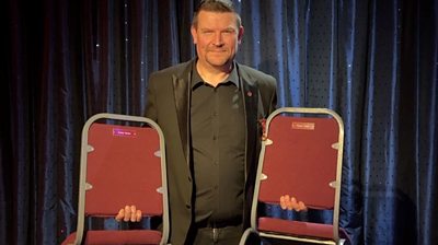 Lee Hathaway of The Magic Circle holding two of the famous chairs