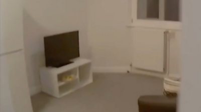 A living room with a TV on a stand and sofa