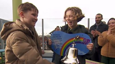 Fundraiser Hughie (left) rings a bell with best friend Freddie alongside him
