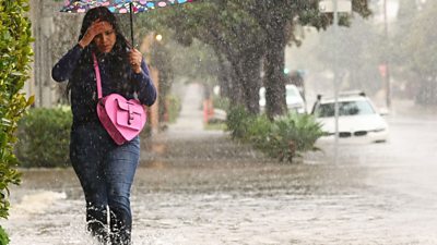 Woman walking on flooded street