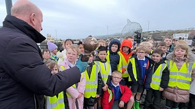 Bill Dale showing the Energy Globe award to pupils