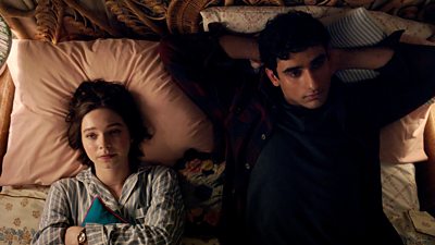 Pip (Emma Myers) and Ravi (Zain Iqbal) lie on a bed staring at the ceiling