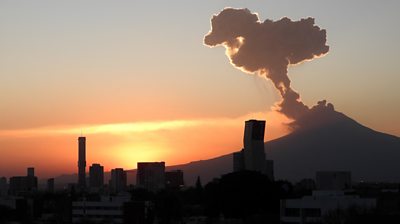 Volcano spewing smoke over a city skyline