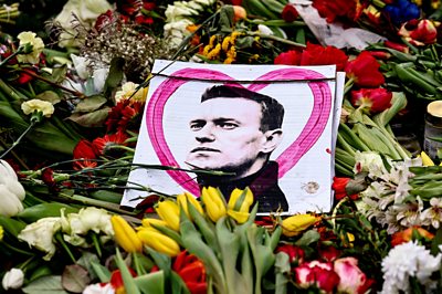 Picture of Navalny on top of floral tributes