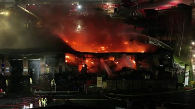 Flames through roof of building