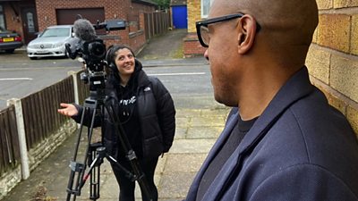 Sarah operates a TV cameras on a tripod