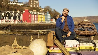 Banjo Beale sits on a pile of fishing equipment in a colourful harbour setting