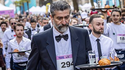 Waiters hold their trays as they take part in the race in Paris.