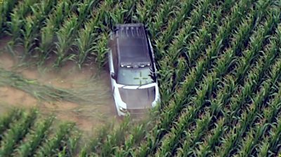 A four-wheel-drive car in a field of crops