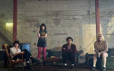 Four young people in a concrete room