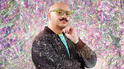 Dominic Skinner with a green and pink diamond effect background