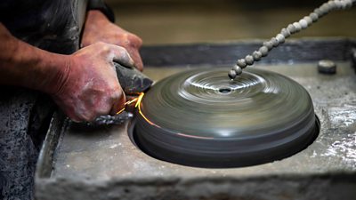A curling stone being polished in a workshop