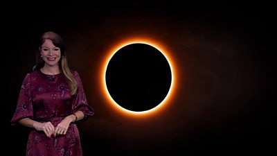 Elizabeth Rizzini in front of a picture of a total solar eclipse