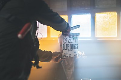 A Blue Lights clapper board in a dingy room