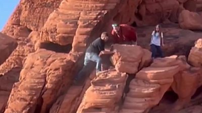 Two people push a rock in Lake Mead, Nevada