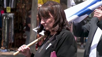 Women with eyes closed holding Israel flag