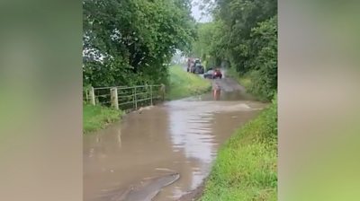 Cars waiting at a flooded ford in Holme Hale, Norfolk.