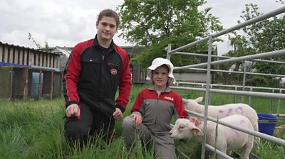 Matthew and Beatice with a lamb on a farm