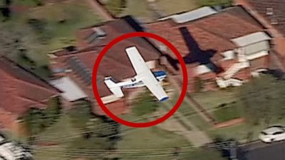 Light plane flies over houses