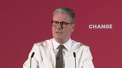 Keir Starmer wearing a white shirt and brown tie