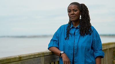 Sharon D Clarke as Claire she's leaning on a ledge looking to the camera with water in the background