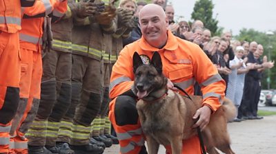 Frankie the retiring service dog with her handler Steven Carr, flanked by members or TWFRS