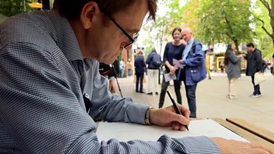 David Bedford drawing outside a restaurant