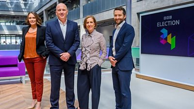 from left to right Laura Miller, Martin Geissler, Kirsty Wark, David Wallace Lockhart stands in the studio with a screen in the background reading BBC Election with the BBC Election logo