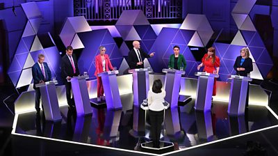 Seven candidates at their podiums facing host Mishal Hussain
