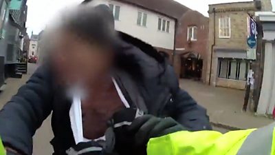 A bodycam view of a police officer trying to arrest a man