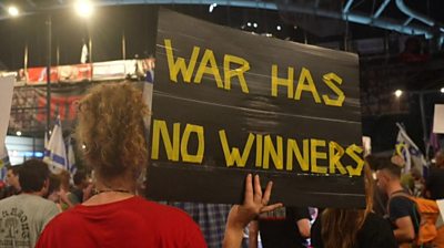 A protester holds up a sign saying 'war has no winners' during an anti-government rally in Tel Aviv, Israel