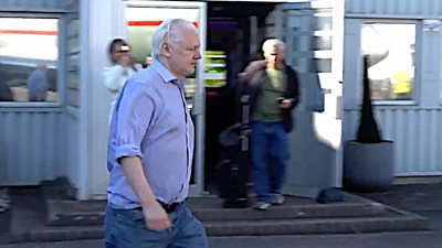 Julian Assange walking on airport tarmac