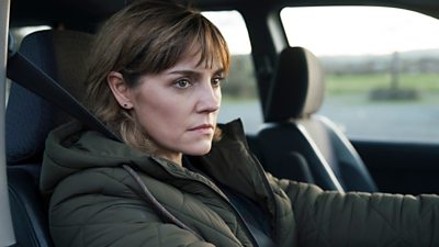 Cathy (Annabel Scholey) sitting in a car looking intensely at something off screen
