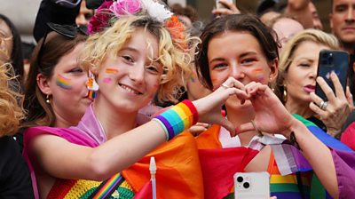 Two people make a heart symbol at London Pride