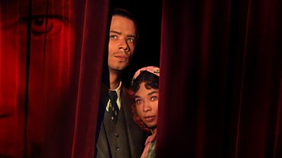 Man and woman with distinct eyes peeking from behind a red velvet curtain. Shadow of someone's face on the curtain