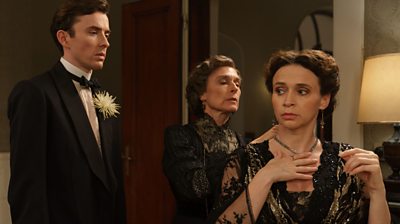 Rachel Liebermann (Amelia Bullmore) puts a necklace on Leah Liebermann (Charlene Mckenna) while Max Liebermann (Matthew Beard) looks on