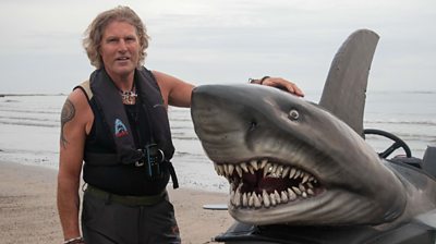 Fin Bowron stood beside his water-worthy creation, the shark boat.